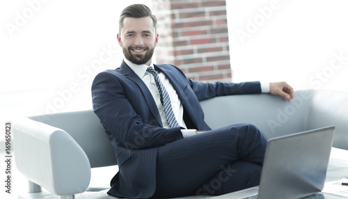 Portrait of a successful businessman sitting in the office lobby