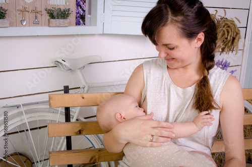 Obraz na płótnie Breastfeeding baby. Young mother holding her newborn child. Mom nursing baby. Woman and new born boy in white bedroom. w salonie