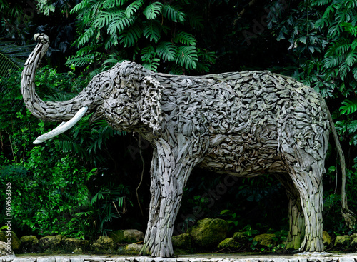 Wooden elephant sculpture decorated on walking way in garden, handmade animal statue