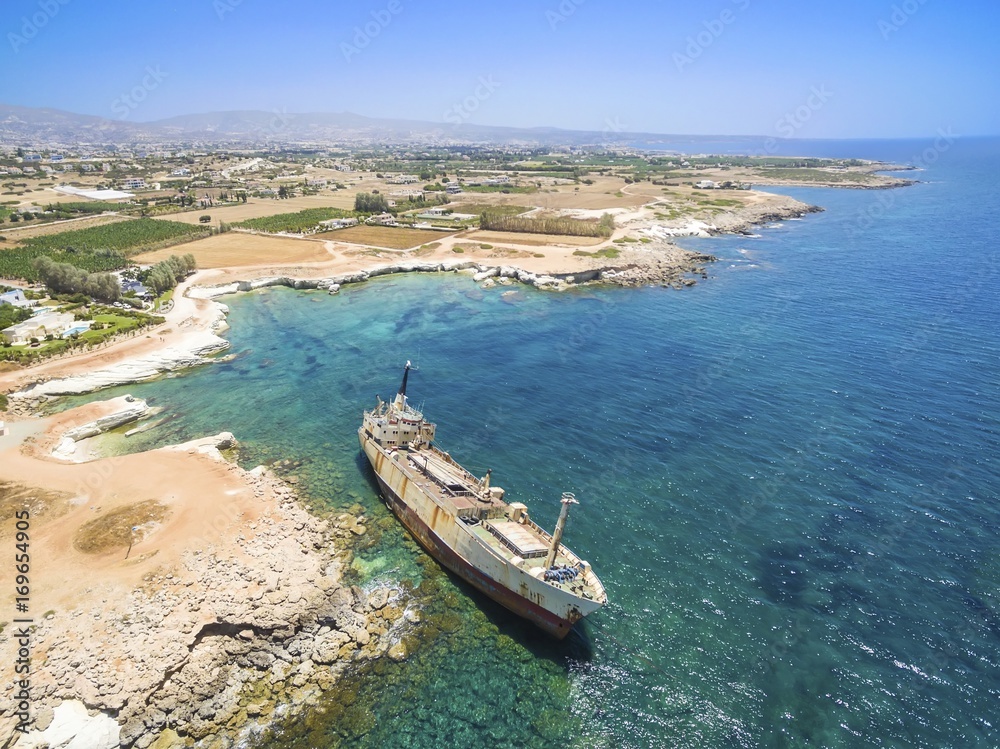 Aerial view of abandoned ship wreck EDRO III in Pegeia, Paphos, Cyprus. The rusty shipwreck is stranded on Peyia rocks at kantarkastoi sea caves, Coral Bay, Pafos, standing at an angle near the shore.