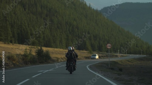 Couple of Motorcyclists on a Motorcycle are Driving along a Beautiful Country Road