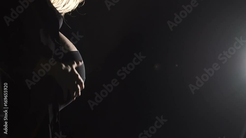 Unrecognizable pregnant woman in dark room