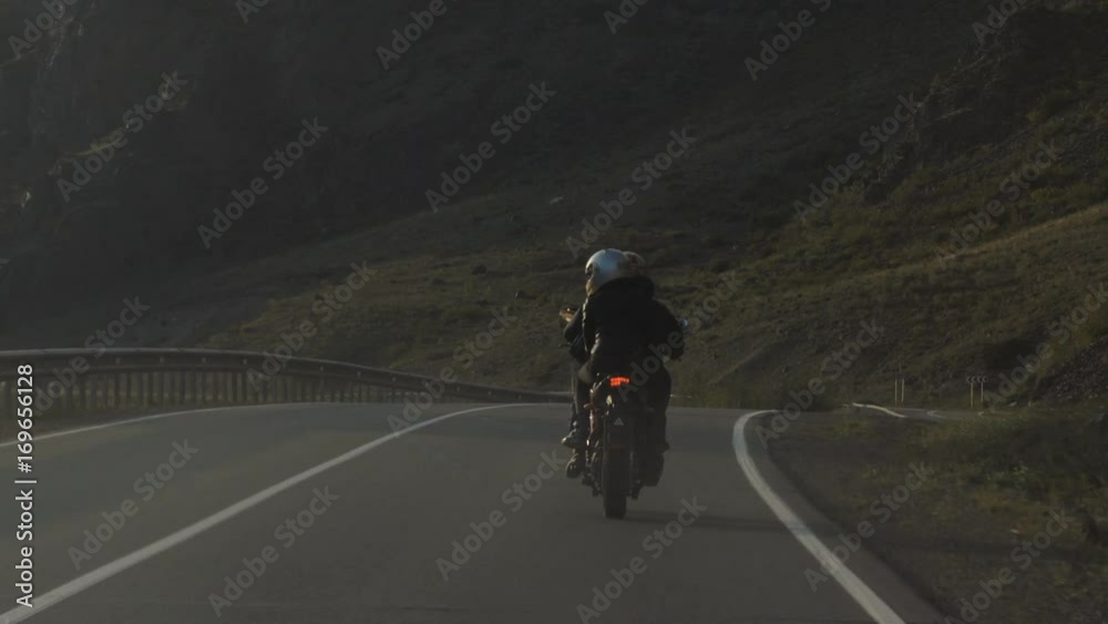 Couple of Motorcyclists are Driving along a Beautiful Road Couple of Motorcyclists are Driving along a Beautiful Road