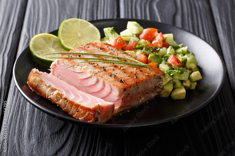 Grilled tuna steak with pepper and avocado cucumber salsa close-up. horizontal Grilled tuna steak with pepper and avocado cucumber salsa close-up. horizontal