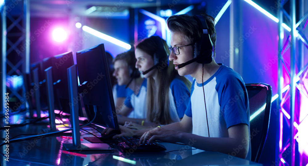 Team of Teenage Gamers Play in Multiplayer PC Video Game on a eSport Tournament. Captain Gives Commands into Microphone, Trying Strategically Win the Game. - obrazy, fototapety, plakaty 