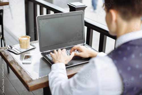 Business man using laptop in coffee shop.