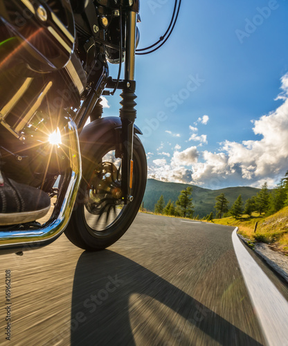 Detail of motorcycle front wheel. Outdoor photography, Alpine landscape.