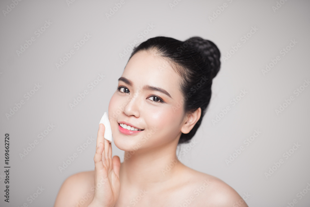 Happy smiling beautiful asian woman using cotton pad cleaning skin. Happy smiling beautiful asian woman using cotton pad cleaning skin.