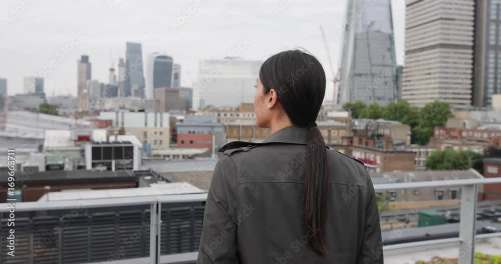Businesswoman looking out at London city skyline Businesswoman looking out at London city skyline