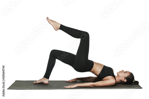Woman exercising on yoga mat. Isolated on white.