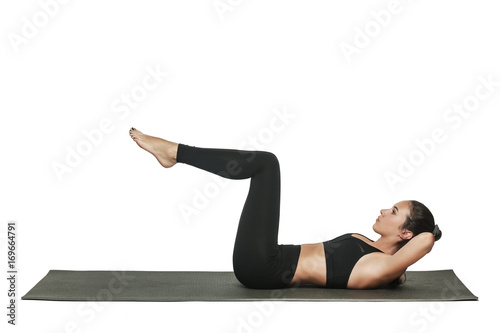 Woman exercising on yoga mat. Isolated on white.