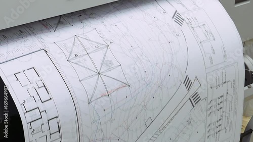 Wide format printer is printing design draft outline sketch drawing in the printing house. Design office supply equipment.