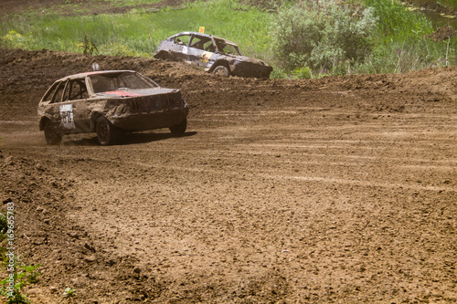 Old wrecked cars stock race. Racing in the open air with dust