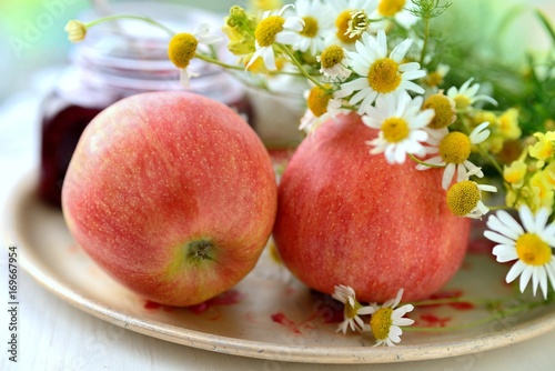 Two apples with chamomile on the plate