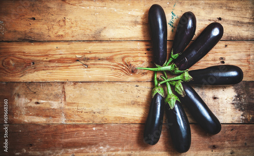 seven ripe eggplant stacked fan on planed boards photo