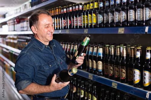 Pensioner selecting a beer at the  store