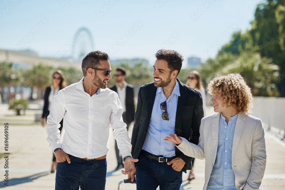 Three happy businessmen having conversation outside Three happy businessmen having conversation outside