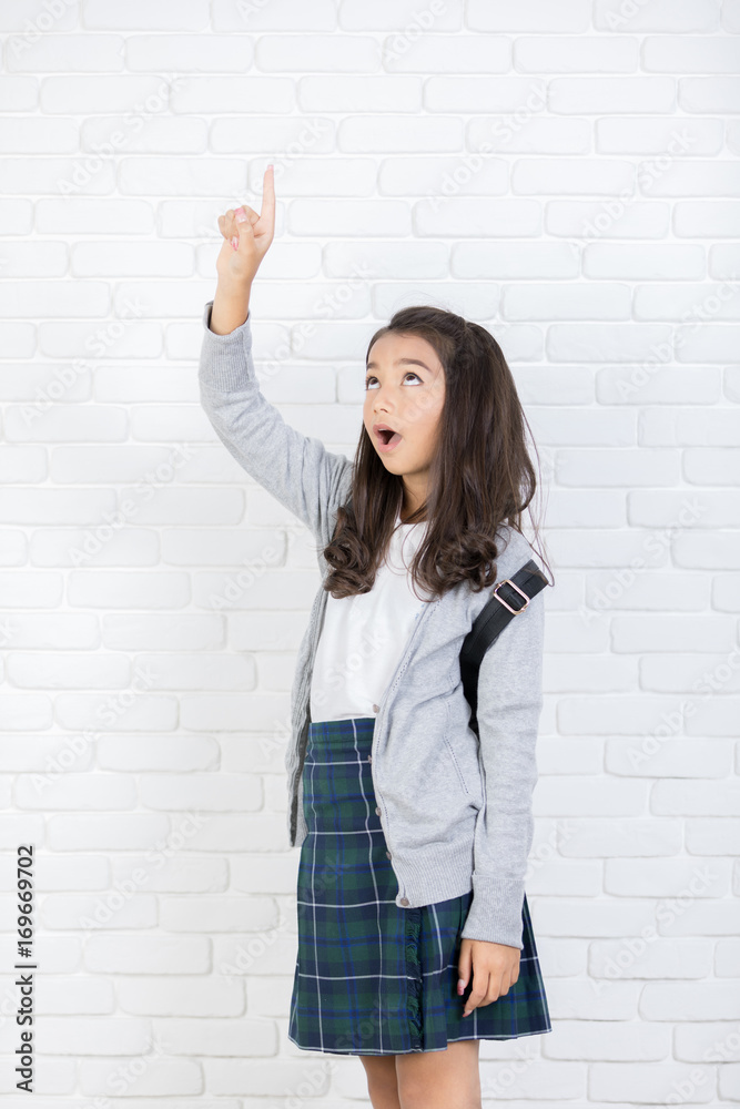 Portrait of a smiling girl pointing finger up at copyspace Portrait of a smiling girl pointing finger up at copyspace