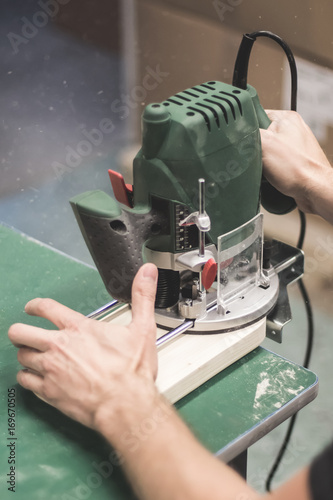 Man cutting wood with a milling machines photo