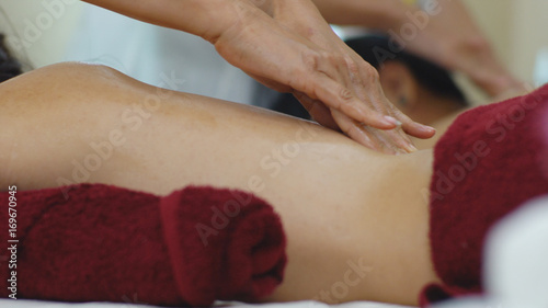 Thai masseur massage oil on back of beautiful woman