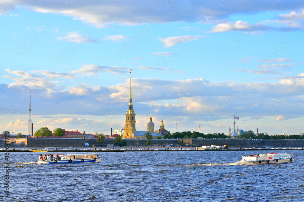 Pleasure boats floating on the Neva river on the background of the Peter and Paul fortress in summer in Saint-Petersburg