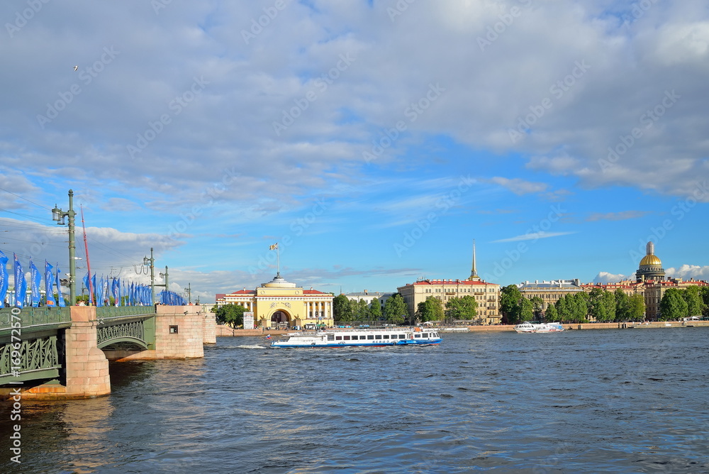 Obraz premium Palace bridge, decorated with flags of the Confederations Cup and tourist boat on the background of the Admiralty embankment