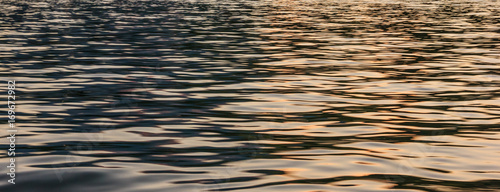 Half Blue, Half Golden Light reflection on river wave ripples surface. Abstract, tranquility, romance.
