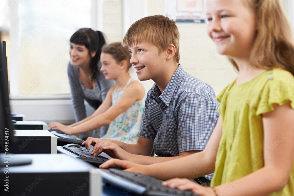 Male Elementary Pupil In Computer Class With Teacher Male Elementary Pupil In Computer Class With Teacher