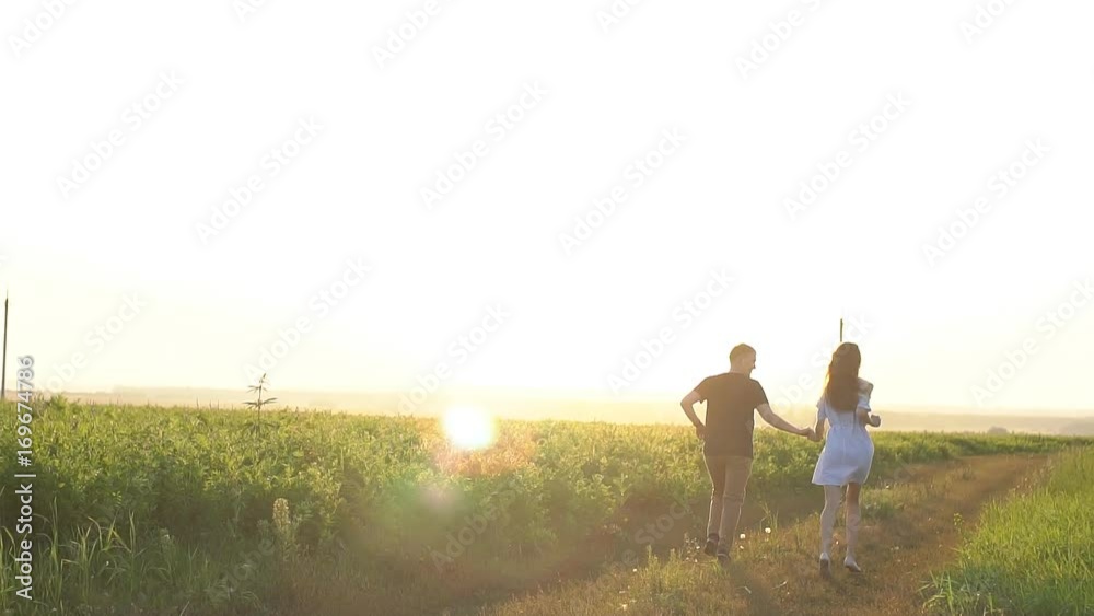Happy couple having fun outdoors. Couple running away on the meadow. Happy couple having fun outdoors. Couple running away on the meadow.