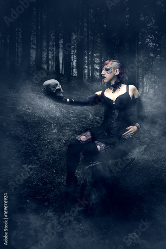 Mystische Frau mit Totenkopf im Wald 