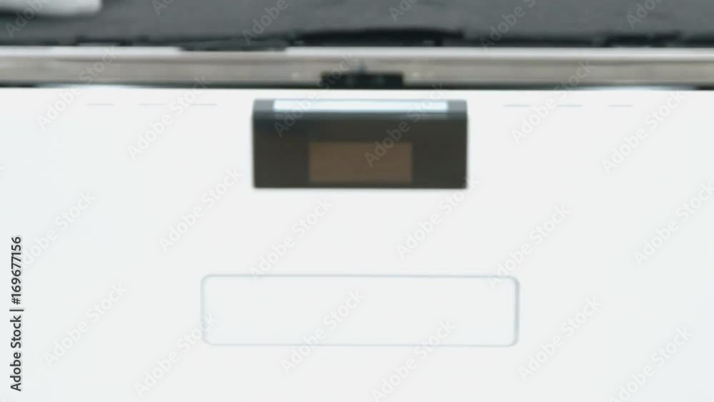 A repairman is trying to slowly close a dishwasher. He is wearing protection gloves when working. He is checking if the dishwasher is working properly. A repairman is trying to slowly close a dishwasher. He is wearing protection gloves when working. He is checking if the dishwasher is working properly.