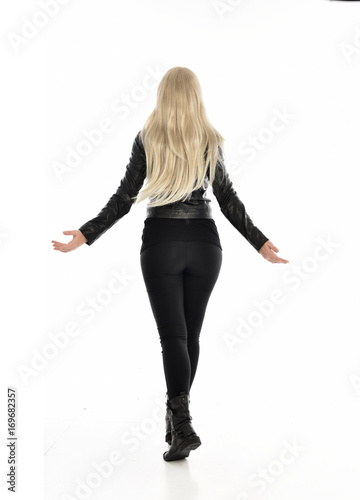 full length portrait of blonde girl wearing black leather outfit, standing pose on white background.