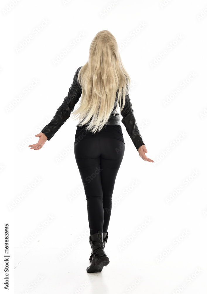 full length portrait of blonde girl wearing black leather outfit, standing pose on white background. full length portrait of blonde girl wearing black leather outfit, standing pose on white background.
