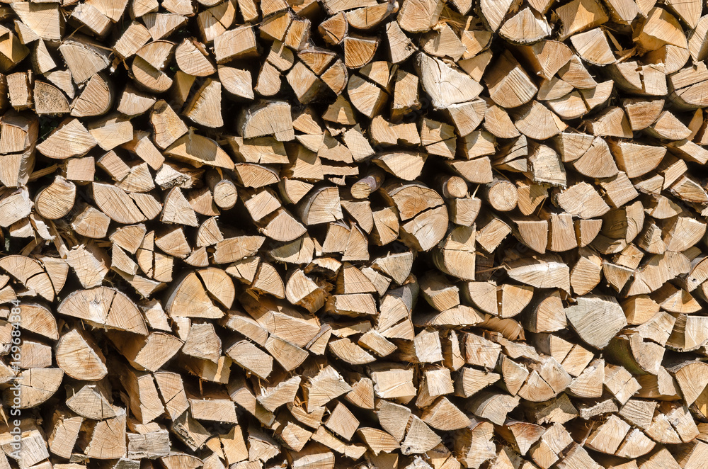 Splitted, dried and stacked firewood, front view. Stack of weathered, dry wood, a source of energy. Photo. Splitted, dried and stacked firewood, front view. Stack of weathered, dry wood, a source of energy. Photo.