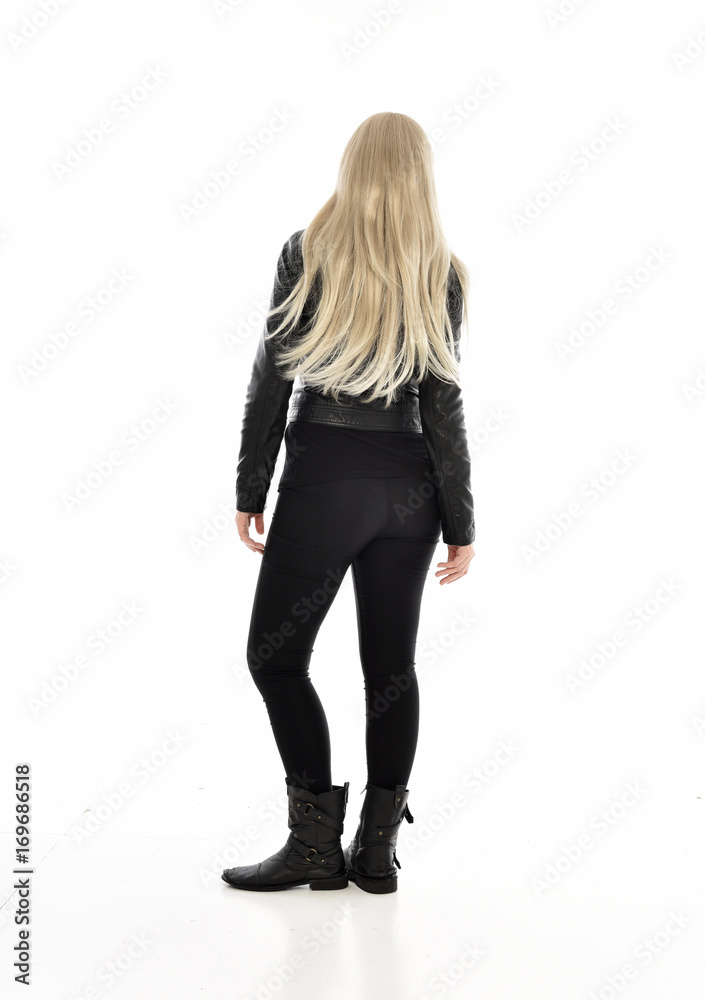 full length portrait of blonde girl wearing black leather outfit, standing pose on white background. full length portrait of blonde girl wearing black leather outfit, standing pose on white background.