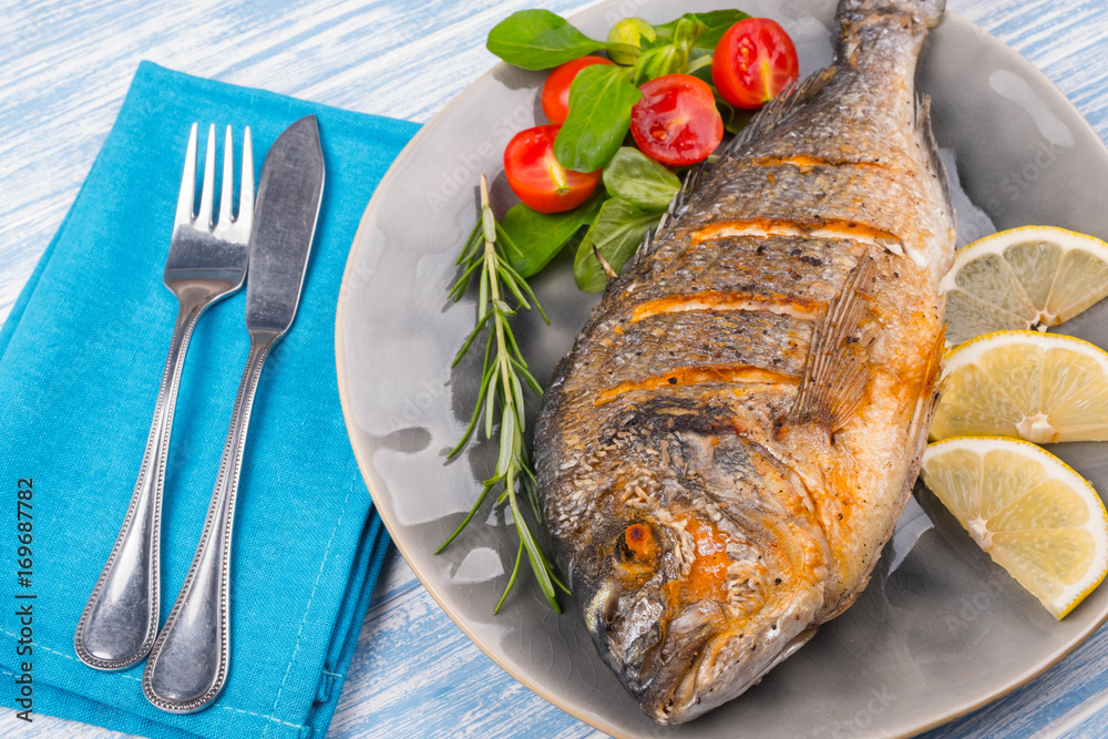 Grilled dorado on plate and wooden Background Grilled dorado on plate and wooden Background