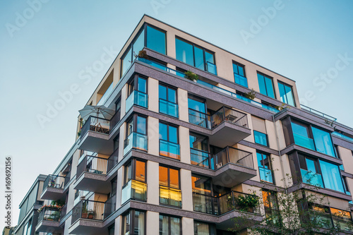 Papier peint modern corner apartment complex with blue colored windows and light leaks