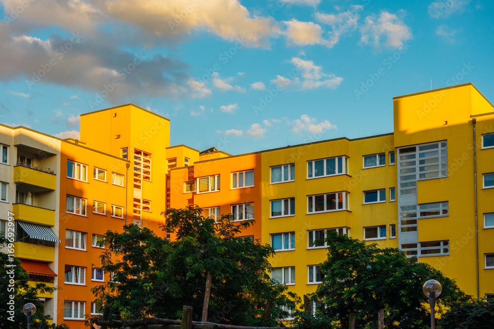 colorful apartment buildings with fluffy clouds