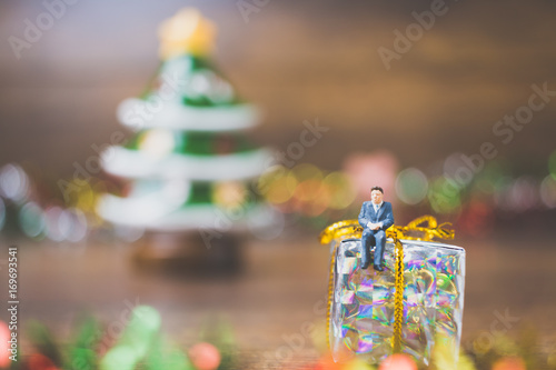 Miniature people on gift box with Christmas Day celebration background © Sirichai Puangsuwan
