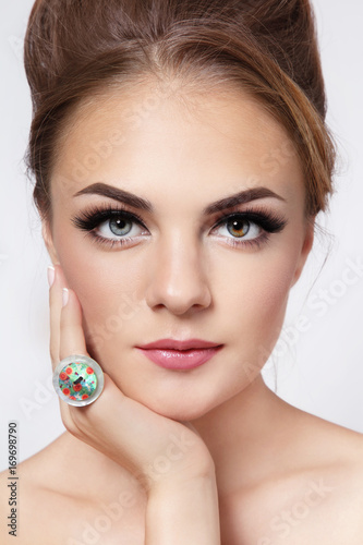 Vintage style portrait of young beautiful girl with hair bun and cat eye make-up photo