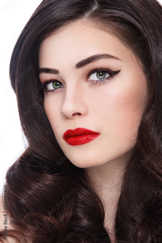 Close-up portrait of young beautiful woman with red lipstick and long curly hair