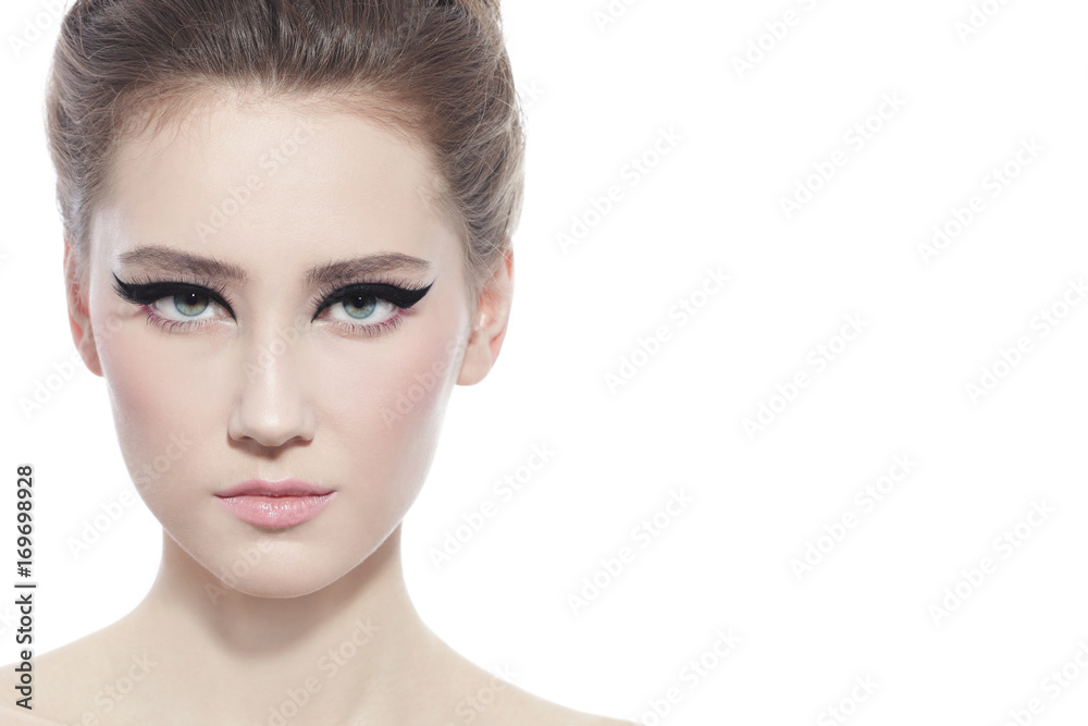 Fototapeta premium Hi-key portrait of young beautiful girl with stylish cat eye make-up over white background, copy space