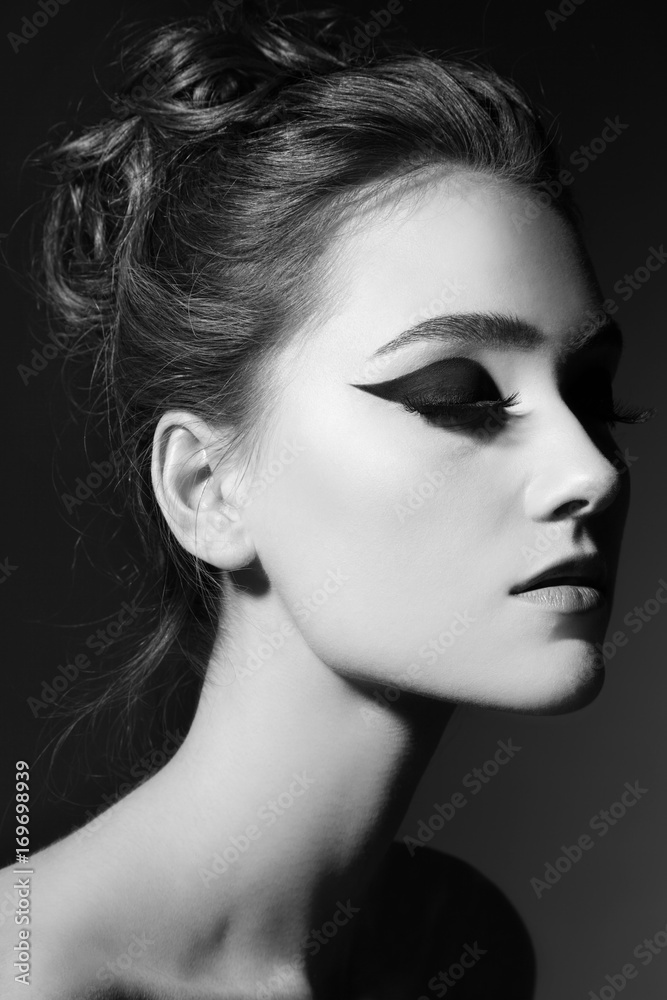 Fototapeta premium Black and white portrait of young beautiful girl with fancy cat eye makeup