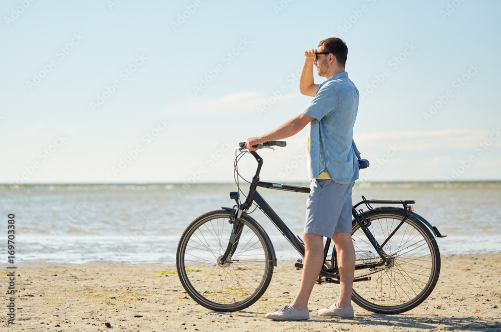 Fototapeta premium happy young man with bicycle on beach 