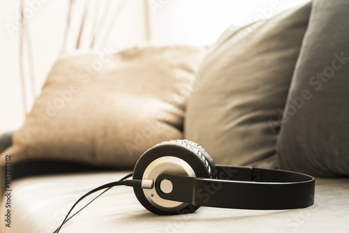 Sound music headphone (earphone) Stereo volume equipment object. Closeup photo of headphones on sofa with blurred background and copyspace area for a text. Audio technology, gadgets and music concept.