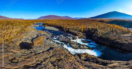 Aerial panorama of the autumn mountains landscape. Waterfall in the National park Putorana in Siberia. Nature and ecology concept.