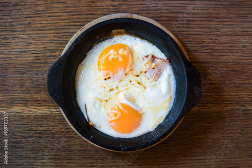 Fried egg in a frying pan, on an old wooden table