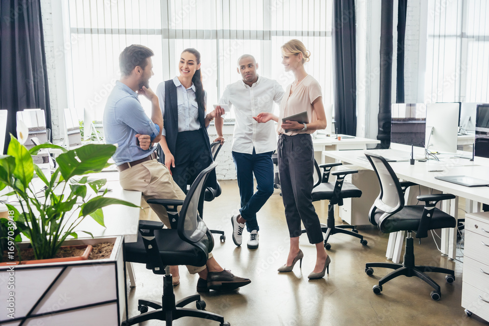 business colleagues talking in office business colleagues talking in office