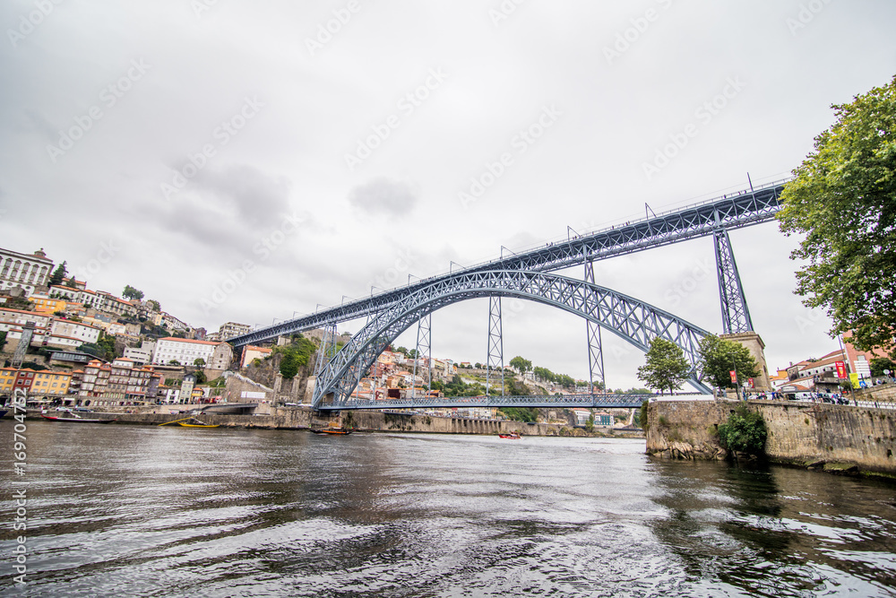 Porto, Portugal - July 2017. View of the iconic Dom Luis I bridge crossing the Douro River, and the historical Ribeira and Se District in the city of Porto, Portugal. Unesco World Heritage Site.