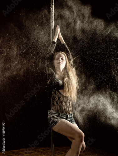 Beautiful expressive dencer dancing at studio with flour photo